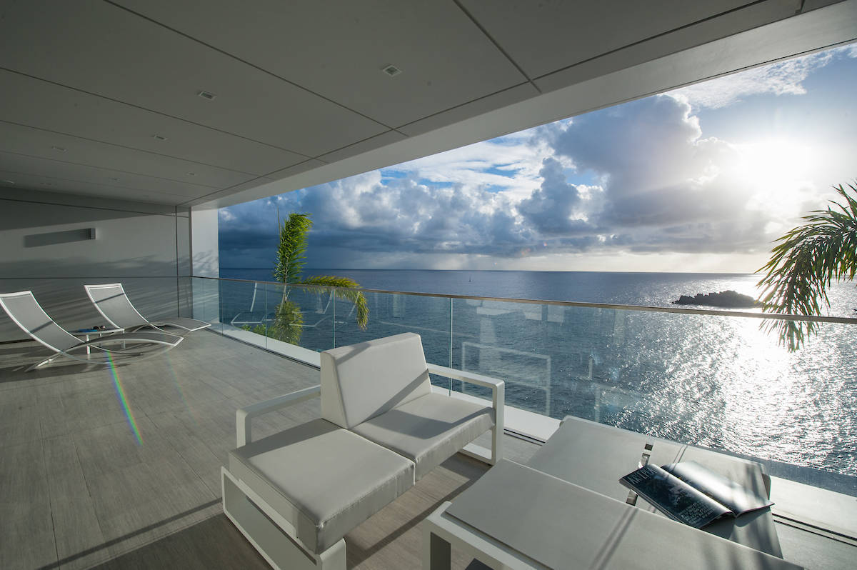 Romantic open-air villa terrace with white sofas and ocean view