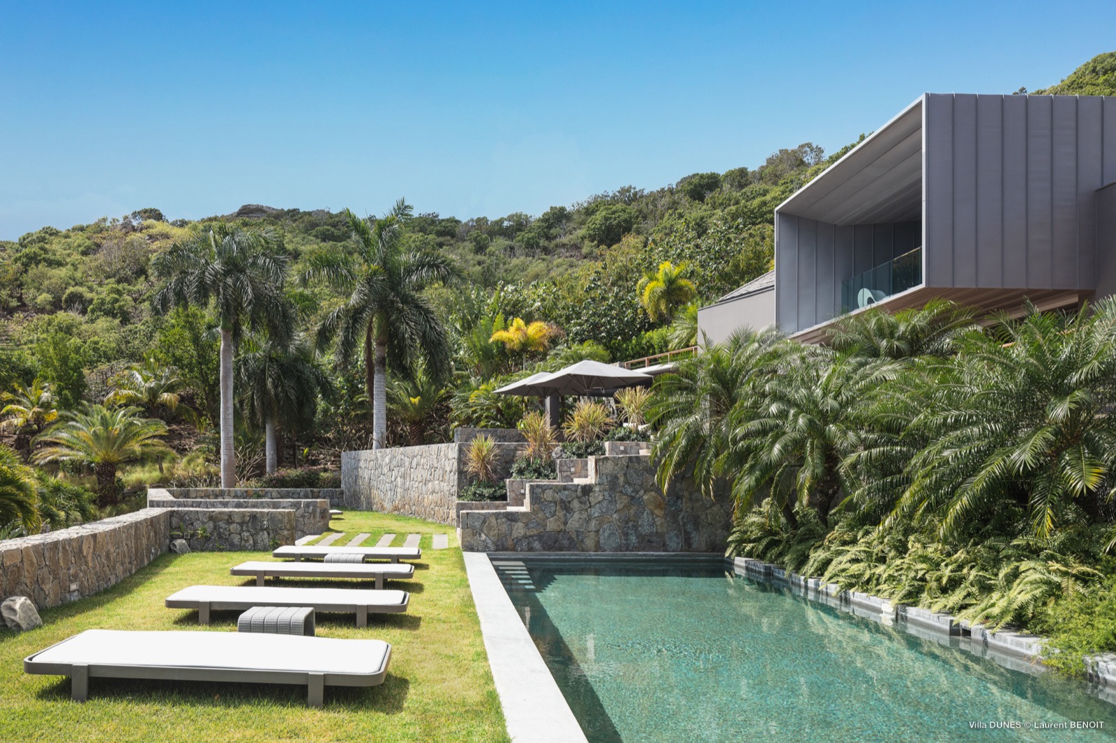 Modern St. Barth villa with private pool, hillside setting, and lush tropical landscaping