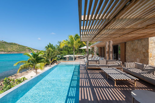 Calm pool framed by a wooden pergola overlooking the lagoon