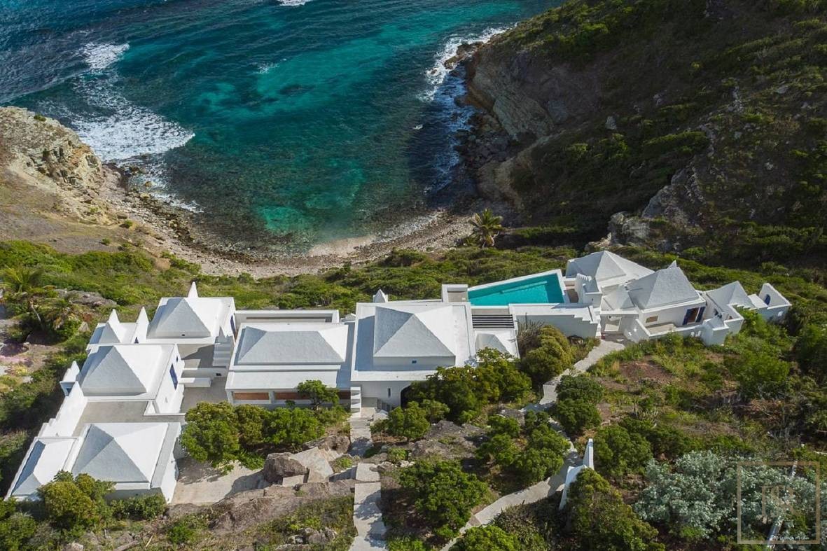 Aerial view of a cliffside villa estate in St. Barth with private pool overlooking the Caribbean